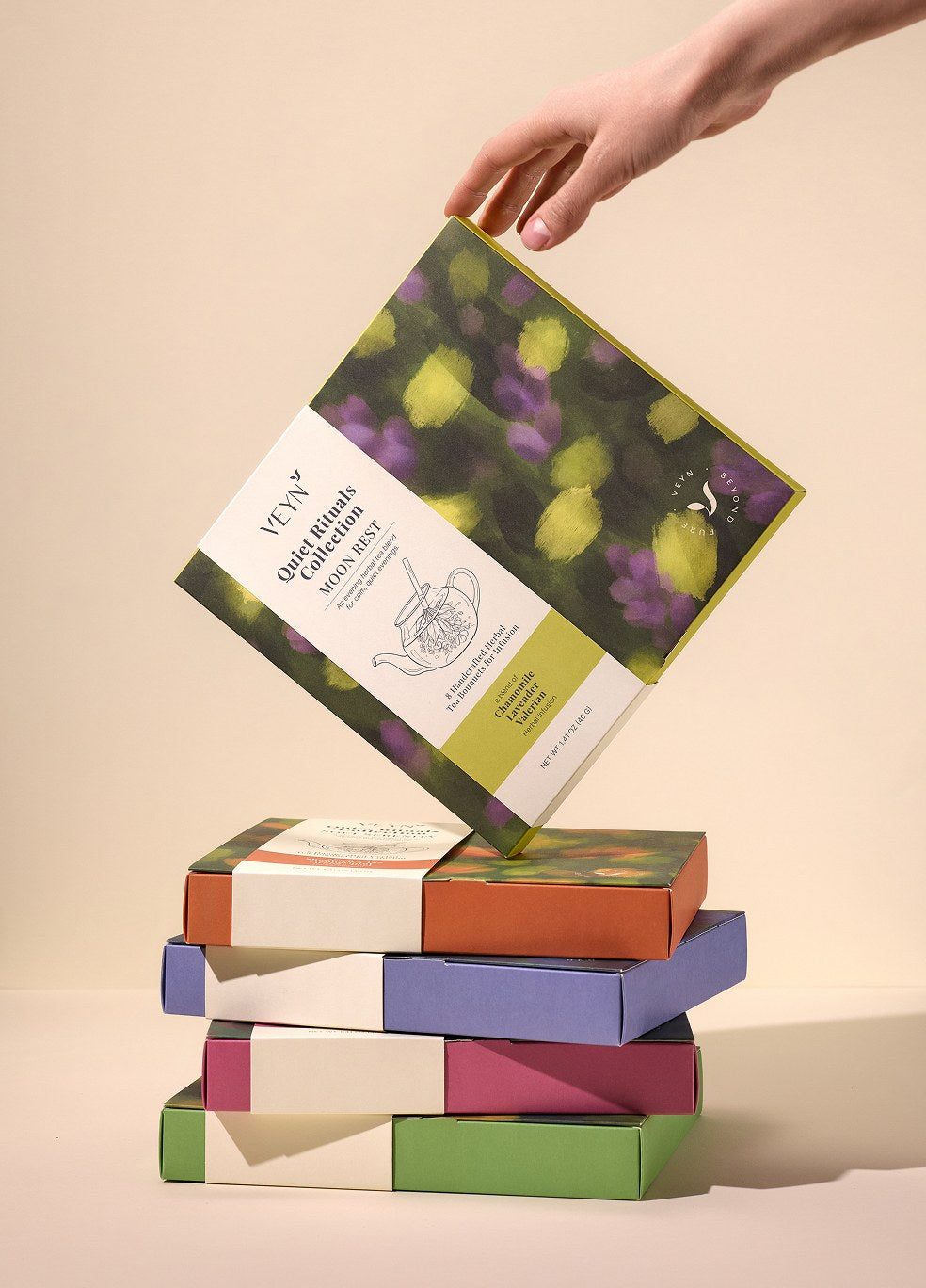 Moon Rest Botanical Tea Bouquet held above the Veyn collection boxes.