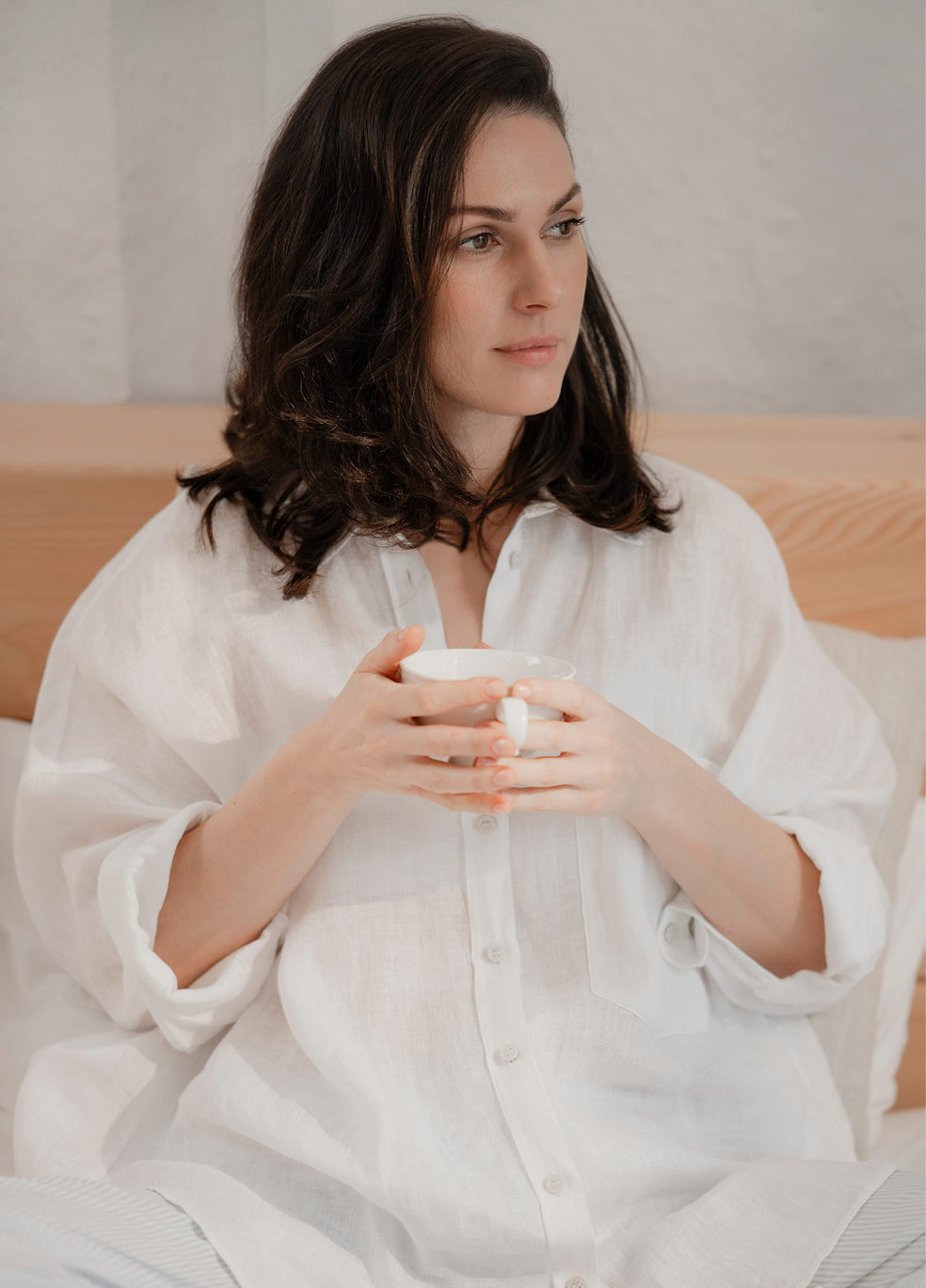 Woman relaxing with a cup of botanical herbal tea in a peaceful home setting, capturing the essence of intentional living, mindfulness, and curated quiet rituals.